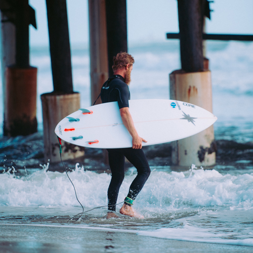 Sprzęt surferski Finy surfer-z-deska-z-czterema-finami-quad-blog-niemafal